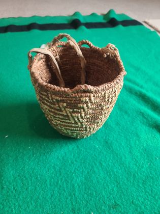 Imbricated coiled cedar-root berry basket with looped rim and buckskin ties, plate 180